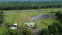 Foto udara warga berdiri di dekat landasan Bandara Pusako Anak Nagari yang sudah tidak beroperasi di Pasaman Barat, Sumatera Barat, Rabu (5/2/2025). 
