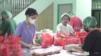 Terlihat dalam gambar ini, para karyawan mengenakan masker dan penutup kepala saat mengemas makanan ke wadah dan kantong plastik. Foto: FYP Trans7