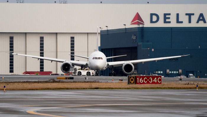 A Japan Airlines jet involved in a collision is towed after the FAA said its right wing struck the tail of a Delta Air Lines plane while the aircraft were taxiing at Seattle-Tacoma International Airport, in SeaTac, Washington, U.S. February 5, 2025. REUTERS/David Ryder
