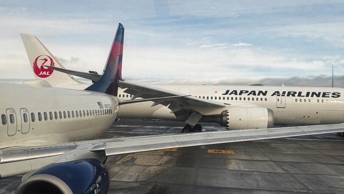 Detik-detik Sayap Japan Airlines Tabrak Buntut Delta Air Lines A Japan Airlines jet involved in a collision is towed after the FAA said its right wing struck the tail of a Delta Air Lines plane while the aircraft were taxiing at Seattle-Tacoma International Airport, in SeaTac, Washington, U.S. February 5, 2025. REUTERS/David Ryder