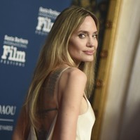 Desain punggung terbuka semakin menambah daya tariknya, menampilkan koleksi tato khas yang menghiasi punggungnya. Penampilannya semakin disempurnakan dengan rambut pirang yang dibiarkan tergerai dalam gelombang lembut, menambah kesan feminin dan berkelas. (Foto: Richard Shotwell/Invision/AP)