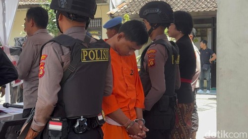 Sudirta (baju tahanan) saat ditahan di Mapolsek Denpasar Selatan setelah terciduk menculik IMRAK dari sekolahnya di Denpasar, Kamis (6/2/2025). (Aryo Mahendro/detikBali)