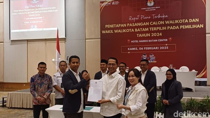 Ketua KPU Batam, Mawardi menyerahkan surat berita acara hasil penetapan Walikota dan Wakil Walikota terpilih kepada Amsakar Achmad-Li Claudia Chandra.