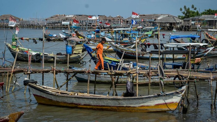 Ribuan Nelayan di Banten Rugi Miliaran Akibat Pagar Laut Seorang anak berjalan di dekat perahu yang bersandar di kawasan pesisir Desa Tanjung Anom, Kabupaten Tangerang, Banten, Kamis (6/2/2025). Ombudsman RI Provinsi Banten mengatakan keberadaan pagar laut di pesisir Kabupaten Tangerang berdampak terhadap 3.888 nelayan dengan total jumlah kerugian mencapai Rp24 mililar terhitung sejak Agustus 2024 hingga Januari 2025. ANTARA FOTO/Putra M. Akbar/nym.