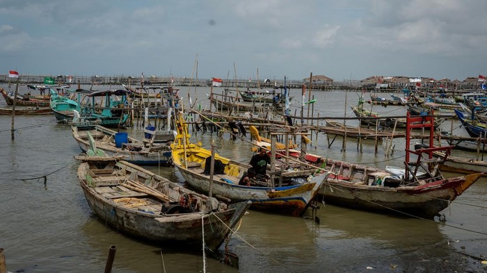Ribuan Nelayan di Banten Rugi Miliaran Akibat Pagar Laut Seorang anak berjalan di dekat perahu yang bersandar di kawasan pesisir Desa Tanjung Anom, Kabupaten Tangerang, Banten, Kamis (6/2/2025). Ombudsman RI Provinsi Banten mengatakan keberadaan pagar laut di pesisir Kabupaten Tangerang berdampak terhadap 3.888 nelayan dengan total jumlah kerugian mencapai Rp24 mililar terhitung sejak Agustus 2024 hingga Januari 2025. ANTARA FOTO/Putra M. Akbar/nym.