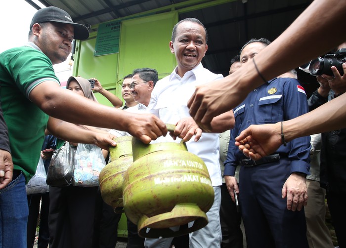 Menteri Energi dan Sumber Daya Mineral (ESDM) Bahlil Lahadalia (tengah) membantu melayani warga yang mengantre membeli gas elpiji 3 kilogram saat melakukan pemantauan di Karawaci, Tangerang, Banten, Selasa (4/1/2025). Bahlil menjamin ketersedian gas elpiji 3 kilogram ditingkat agen seluruh Jabodetabek, serta menjamin juga gas akan ada kembali di tingkat pengecer. ANTARA FOTO/Muhammad Iqbal/YU