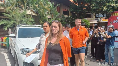 Bule Inggris berinisial PA (pria berbaju tahanan oranye nomor 46) cengar-cengir saat digiring polisi dalam konferensi pers di Mapolda Bali, Jumat (7/2/2025). (Foto: Aryo Mahendro/detikBali)