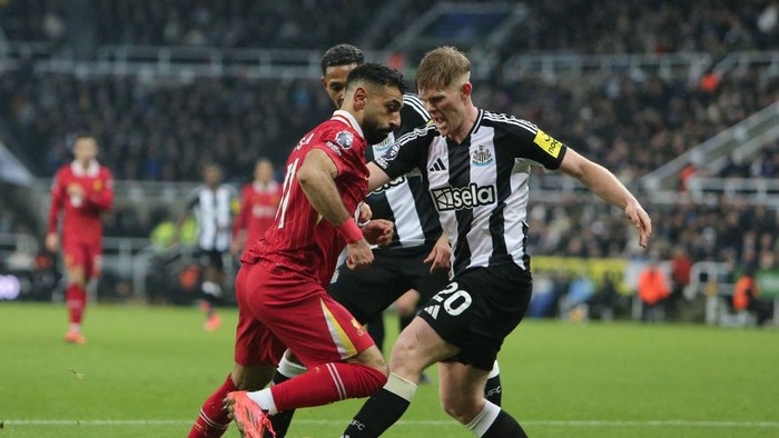 Newcastle Uniteds Lewis Hall tackles Liverpools Mohamed Salah during the Premier League match between Newcastle United and Liverpool at St. Jamess Park in Newcastle, United Kingdom, on December 4, 2024. (Photo by MI News/NurPhoto via Getty Images)