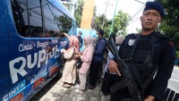 Sejumlah warga mengantre untuk menukarkan uang dengan penjagaan polisi bersenjata laras panjang.