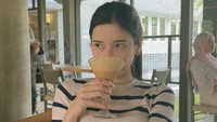 Kalau ini potret Iris ketika ngafe di Bandung. Ia menikmati secangkir minuman yang tampak seperti coffee mocktail tersebut. Sepertinya creamy ya? Foto: Instagram iriswullur_
