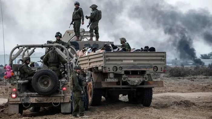 Palestinian detainees sit in a truck as Israeli soldiers guard around amid the ongoing conflict between Israel and the Palestinian group Hamas, in the Gaza Strip December 8, 2023. (Reuters)