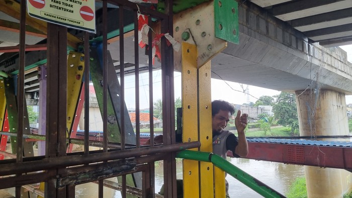 Warga memanjat dari sisi samping JPO kolong flyover Kalibata untuk melewati pagar yang menujupi akses mereka (Taufiq/detikcom)