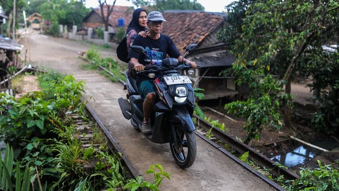 Seorang warga berjalan di jembatan jalur rel kereta api nonaktif Rangkasbitung-Pandeglang di Kadomas, Pandeglang, Banten, Jumat (7/2/2025). Pemerintah menargetkan reaktivasi jalur kereta api nonaktif Rangkasbitung-Labuan sepanjang 56,6 kilometer pada tahun 2027 untuk tahap pembangunan konstruksi pada segmen pertama yaitu Rangkasbitung-Pandeglang sepanjang 18,7 kilometer, dengan jumlah bangunan terdampak penggusuran mencapai 1.326 bangunan yang tersebar di 13 desa di Kabupaten Lebak dan dua desa di Kabupaten Pandeglang. ANTARA FOTO/Muhammad Bagus Khoirunas/YU