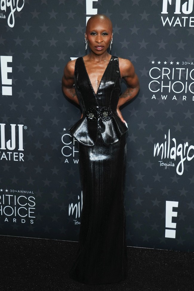  Out of comfort zone. Istirahat sejenak dari gaun-gaun Louis Vuitton yang selama ini kerap menjadi andalannya, bintang Wicked Cynthia Erivo kali ini bersolek dengan gaun hitam berbelahan dada rendah yang dilengkapi peplum dari Armani Prive.   (Foto: Jordan Strauss/Invision/AP)
