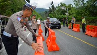 Polisi telah dikerahkan untuk mengatur lalu lintas di jalan yang longsor. 