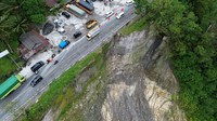 Foto udara kendaraan melintas di Jalan Raya Padang-Bukittinggi yang longsor, Sabtu (8/2/2025).