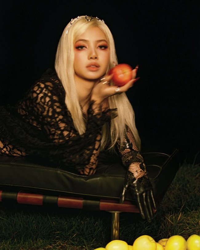 Rambut pirangnya yang panjang ditata lurus, memberikan kontras menarik dengan busana gelapnya. Aksesori sederhana, seperti cincin dan detail kepala minimalis, melengkapi penampilan ini tanpa mengurangi fokus pada busana utamanya. Foto: Instagram/@lalalalisa_m @dojacat