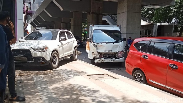 Mobil box roti menabrak mobil SUV di Palembang hingga terbang ke trotoar.