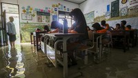 Sejumlah siswa mengikuti kegiatan belajar mengajar di salah satu ruang kelas yang terendam banjir di SDN Eretan, Tirtayasa, Kabupaten Serang, Banten, Sabtu (8/2/2025).
