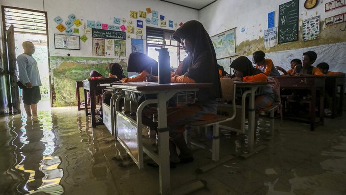 Potret Siswa SDN Eretan Serang Belajar di Tengah Banjir Sejumlah siswa bermain air di depan ruang kelas yang terendam banjir di SD Negeri Eretan, Tirtayasa, Kabupaten Serang, Banten, Sabtu (8/2/2025). Pihak sekolah menyebutkan sejak enam tahun terakhir sekolah tersebut menjadi langganan banjir akibat luapan saluran irigasi yang ada di sekitar area sekolah dengan ketinggian air sekitar 25-30 centimeter dan merendam sebanyak enam ruang kelas, satu ruang guru, dan dua gudang sekolah. ANTARA FOTO/Angga Budhiyanto/rwa.