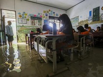 Potret Siswa SDN Eretan Serang Belajar di Tengah Banjir