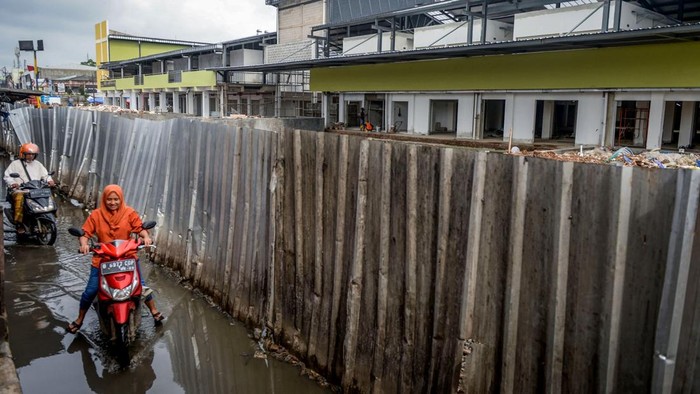 Dua pengendara sepeda motor melintas di depan proyek revitalisasi Pasar Anyar di Kota Tangerang, Banten, Jumat (7/2/2025). Pemerintah Kota Tangerang menargetkan revitalisasi pasar yang termasuk dalam program Proyek Strategis Nasional (PSN) tersebut selesai pada Februari 2025 dan saat ini telah mencapai 97,5 persen. ANTARA FOTO/Putra M. Akbar/app/YU