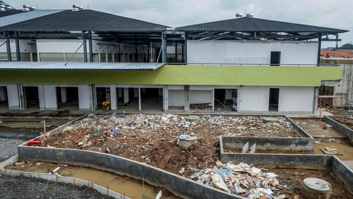 Dua pengendara sepeda motor melintas di depan proyek revitalisasi Pasar Anyar di Kota Tangerang, Banten, Jumat (7/2/2025). Pemerintah Kota Tangerang menargetkan revitalisasi pasar yang termasuk dalam program Proyek Strategis Nasional (PSN) tersebut selesai pada Februari 2025 dan saat ini telah mencapai 97,5 persen. ANTARA FOTO/Putra M. Akbar/app/YU