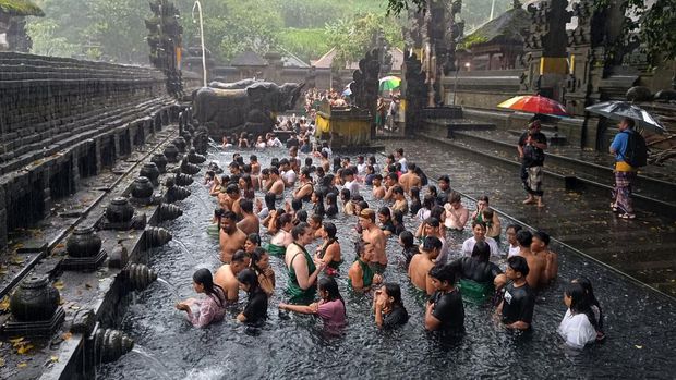 Umat Hindu berbaur dengan wisatawan mancanegara saat melakukan ritual melukat atau pembersihan diri pada hari Banyu Pinaruh di Pura Tirta Empul, Tampaksiring, Gianyar, Bali, Minggu (9/2/2025). Umat Hindu di Bali tetap menjalani ritual yang digelar setiap enam bulan sekali yakni sehari setelah Hari Raya Saraswati tersebut meski hujan deras mengguyur kawasan itu. ANTARA FOTO/Nyoman Hendra Wibowo/foc.