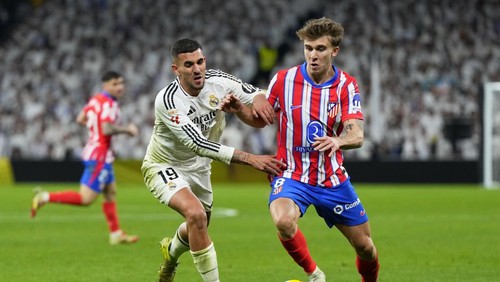 Real Madrids Dani Ceballos vies for the ball with Atletico Madrids Pablo Barrios, right, during a Spanish La Liga soccer match between Real Madrid and Atletico Madrid at the Santiago Bernabeu stadium in Madrid, Saturday, Feb. 8, 2025. (AP Photo/Manu Fernandez)