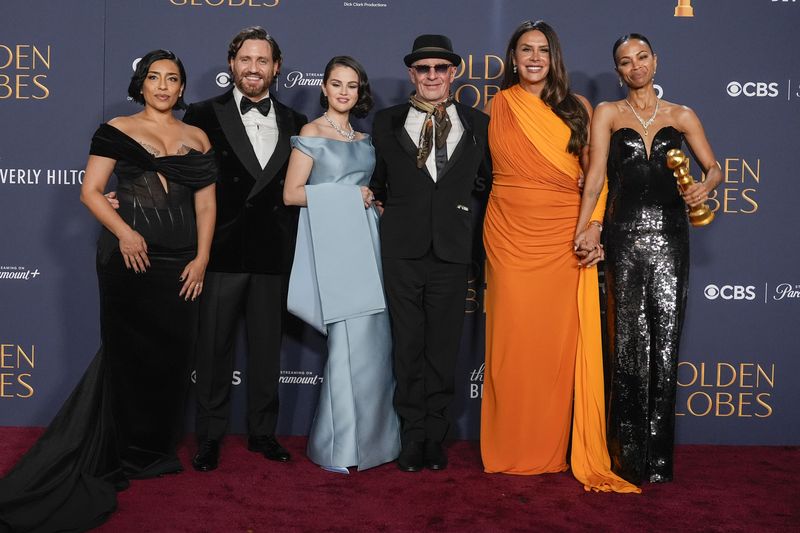 Adriana Paz, from left, Edgar Ramirez, Selena Gomez, Jacques Audiard, Karla Sofia Gascon, and Zoe Saldana pose in the press room with the award for best motion picture - musical or comedy for 