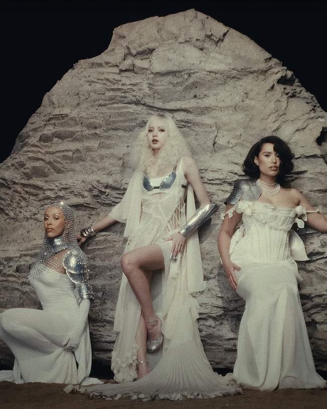 Sejumlah penggemar menduga Lisa BLACKPINK, Doja Cat, dan RAYE menggambarkan dewa mitologi Yunani. Saat trio tersebut muncul dalam satu frame, Lisa mengenakan sheer swimsuit yang dibalut ornamen bralette berwarna silver dan sheer dress keluaran brand fashion, DSQUARED2. Koleksi gaunnya dibanderol dengan harga fantastis mencapai $5,995 atau Rp 97 juta. Foto: dok. YouTube LLOUD