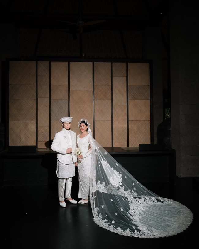 Veil panjang menyapu lantai berhias bordiran menambah kesan elegan dan dramatis. Hiasan kepala warna silver melengkapi elegansi gaya aktris berdarah Minang ini. Foto: Instagram/@sheninacinnamon @iluminen