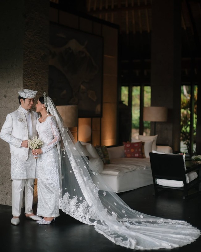 Shenina Cinnamon cantik sekaligus anggun dalam balutan kebaya lace putih berhias payet rancangan Didiet Maulana. Kebaya dipadukan dengan kain songket yang juga berwarna putih bersih. Foto: Instagram/@sheninacinnamon @iluminen