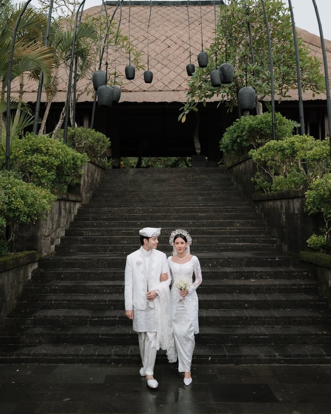 Angga Yunanda juga memakai setelan serba putih berupa padanan kemeja kerah tinggi, jas dan celana yang diberi aksen sarung dari kain songket. Foto: Instagram/@sheninacinnamon @iluminen