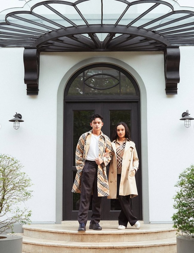 Randy dan Lyodra tampil memadukan coat coklatnya dengan celana panjang berwarna hitam. Coat yang dikenakan Randy tampak memiliki motif kotak-kotak khas Burberry. Sementara coat yang dikenakan Lyodra polos tanpa motif. Penyanyi 21 tahun itu kemudian memadukannya dengan jaket kotak-kotak khas Burberry sebagai dalamannya. Foto: Instagram/@prillylatuconsina96/@randymartinnn