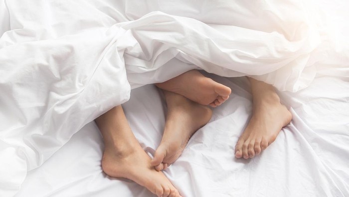 Young couple man and woman intimate relationship on bed feet
