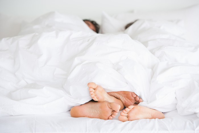 Young couple man and woman intimate relationship on bed feet
