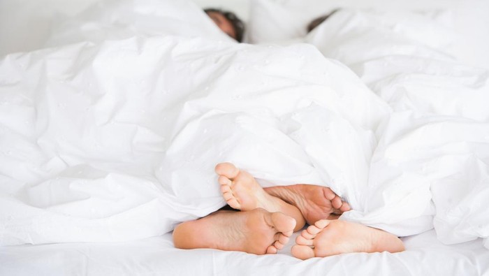 Young couple man and woman intimate relationship on bed feet