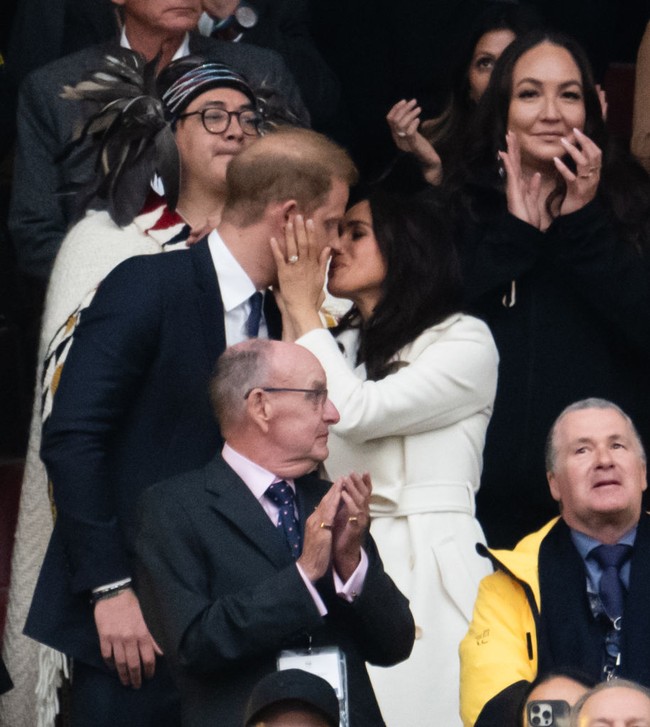 Dalam momen yang penuh kehangatan, keduanya berbagi ciuman mesra sebelum Pangeran Harry naik ke panggung untuk menyampaikan pidatonya. Foto: Getty Images