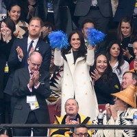 Awalnya, pasangan ini terlihat bertepuk tangan dan melambaikan pom pom biru ke udara saat upacara pembukaan dimulai. Foto: Getty Images