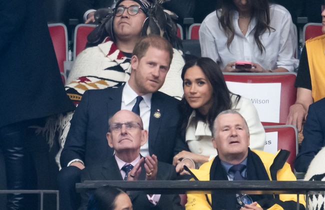 Meghan Markle kemudian terlihat memeluk Pangeran Harry ketika dia kembali ke tempat duduknya. Foto: Getty Images
