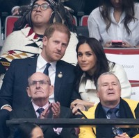 Meghan Markle kemudian terlihat memeluk Pangeran Harry ketika dia kembali ke tempat duduknya. Foto: Getty Images