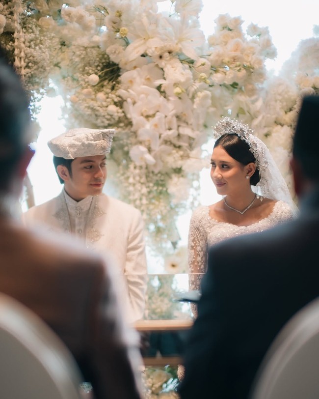 Dekorasi pelaminan pun dibuat serba putih dengan berbagai kombinasi bunga. Tampak modern, minimalis, tapi di sisi lain juga terlihat elegan. Akad nikah dilangsungkan di Bvlgari Resort Bali. Foto: Instagram @angga/ @sheninacinnamon