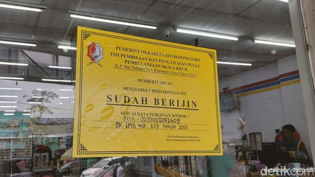 Petugas gabungan Bojonegoro memasang stiker tanda minimarket sudah berizin untuk membedakannya dengan yang bodong.