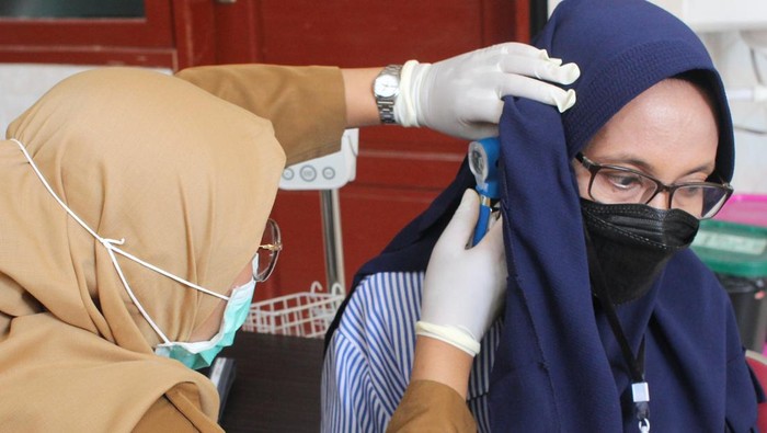 Petugas kesehatan memeriksa rongga telinga warga saat pemeriksaan kesehatan gratis di Puskesmas Manukan Kulon, Surabaya, Jawa Timur, Senin (10/2/2025). Program Pemeriksaan Kesehatan Gratis di Surabaya mulai dilaksanakan di puskesmas-puskesmas dengan menyasar bayi, balita, orang dewasa, dan lansia. ANTARA FOTO/Didik Suhartono/tom.