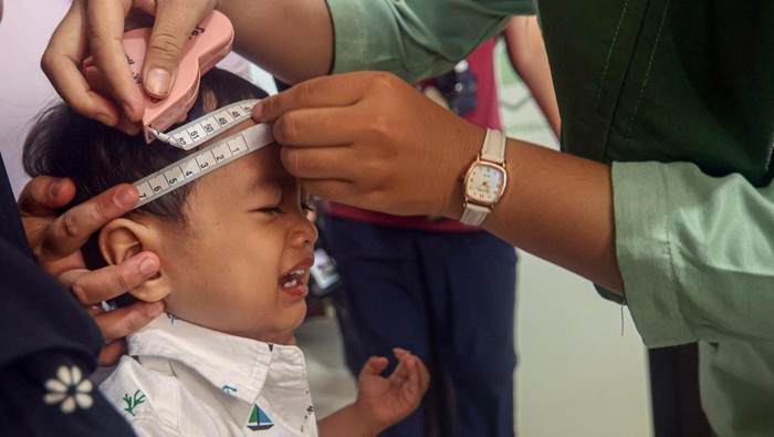 Petugas kesehatan memeriksa lingkar kepala anak saat pelaksanaan Pemeriksaan Kesehatan Gratis di Puskesmas Beji, Depok, Jawa Barat, Senin (10/2/2025). Kementerian Kesehatan memastikan telah melakukan persiapan yang matang untuk melayani masyarakat di 10.200 puskesmas di seluruh Indonesia dalam program Pemeriksaan Kesehatan Gratis yang diharapkan dapat memberikan pengecekan kesehatan bagi seluruh lapisan masyarakat mulai dari bayi hingga lansia. ANTARA FOTO/Yulius Satria Wijaya/tom.