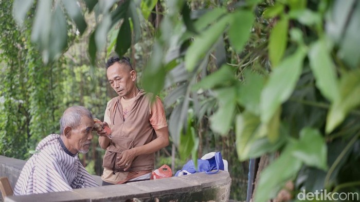 Sejuk, Asyik, Potong Rambut di Bawah Pohon Sudah 23 tahun, Idrus membuka usaha potong rambut di baah pohon di kawasan Jalan Otista, Bogor, Jawa Barat. Hawa sejuk menyelimuti prosesi potong rambut.