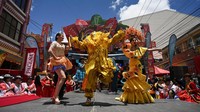 Seorang pria berpakaian seperti El Pepino menari bersama Ariane Torrico, Ratu Karnaval Santa Cruz, dan Perla Potosina, Marcela Ugalde, selama upacara yang menandai dimulainya karnaval di La Paz, Bolivia, Minggu (9/2/2025).
