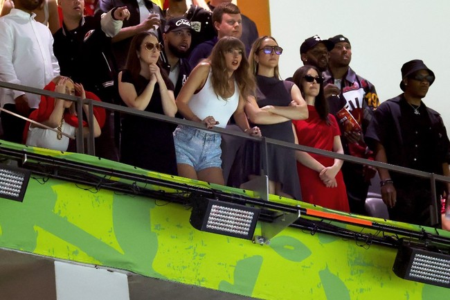 Taylor Swift tertangkap kamera bersandar pada pagar area VIP dengan mulut terbuka lebar karena terkejut ketika Eagles memimpin 24-0 atas Chiefs di kuarter kedua. Foto: Dok. AP Photo, AFP Photo