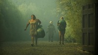 Orang-orang membawa barang-barang mereka setelah kebakaran hutan menyebar di dekat Lautaro, Chile, Minggu (9/2/2025). 
